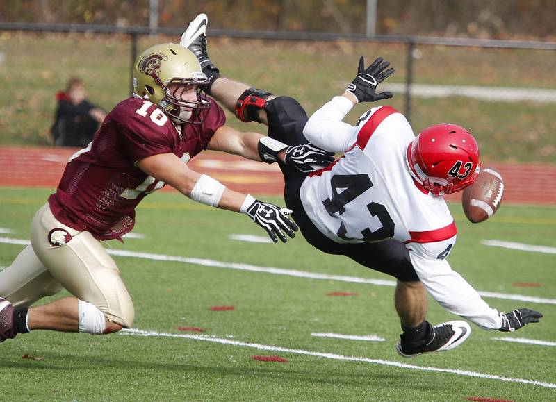 Andrew Libby of Thornton Academy, left, knocks the ball away from Scarbrorough's Kenny Adams on a second-quarter pass attempt in the Western Class A semifinals Saturday. The Trojans won, 49-14.