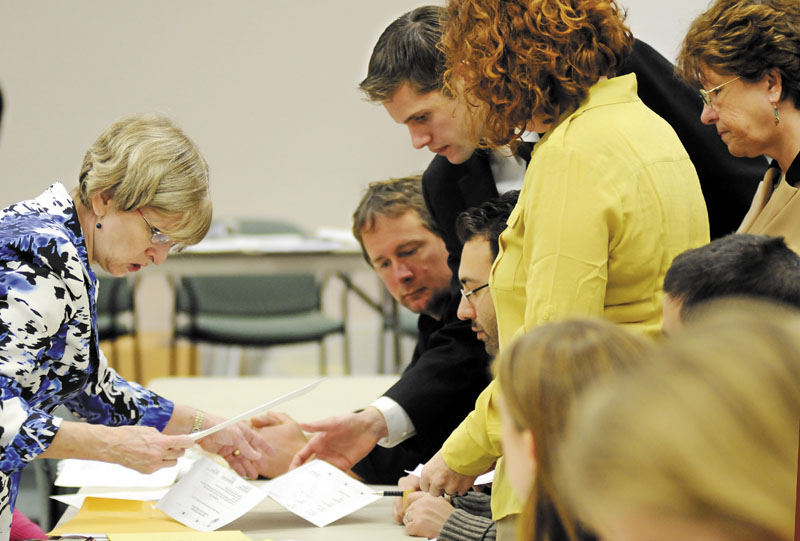 Deputy Secretary of State Julie Flynn, left, examines a ballot Monday during a recount in Augusta for House District 45. Challenger Brian Jones, D-Freedom, defeated Rep. Ryan Harmon, R-Palermo.