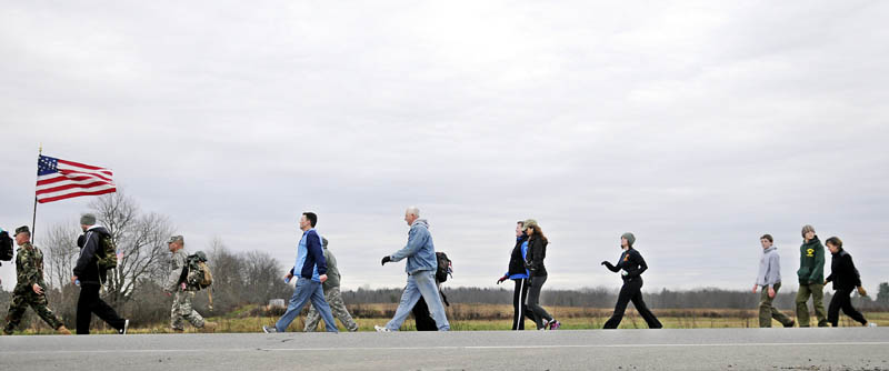 Kennebec County Sheriff Randy Liberty carries the colors Sunday through Vassalboro, on the annual Veterans Day Road March between Augusta and Winslow. Participants hiked 21 miles to remember service members.