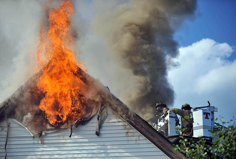 Waterville firefighters battle a blaze at the corner of Drummond Avenue and Spruce Street in Waterville. Authorities blame the fire on faulty wiring in the attic. The fire displaced two families.