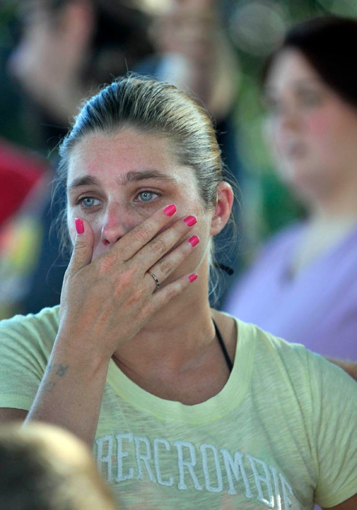 Janet White wipes tears from her cheek as Waterville firefighters battle a blaze that engulfed her apartment building on the corner Drummond Avenue and Spruce Street in Waterville.