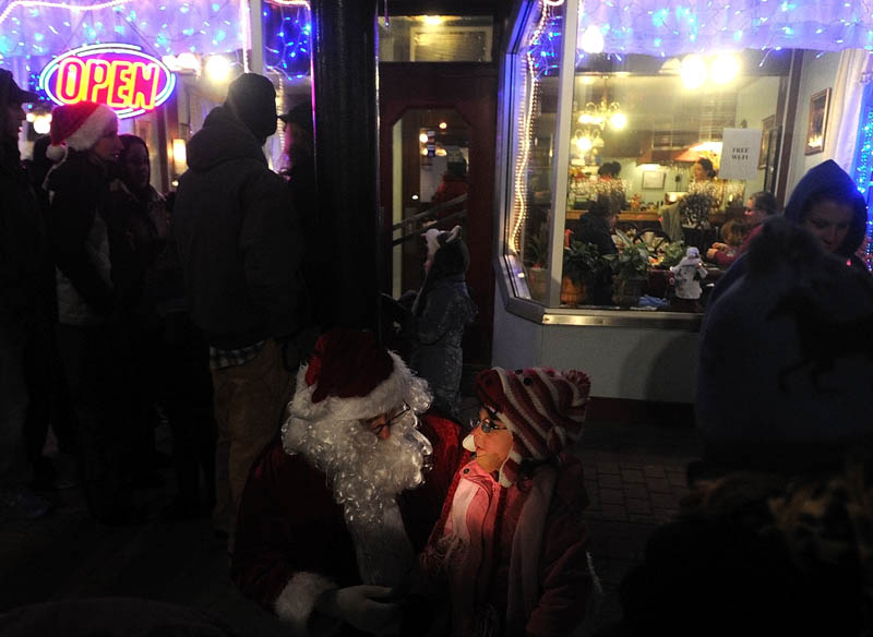 Santa Claus listens carefully to Laura Harding, 3, of Harmony, as she offers a list of gifts she would would like to see under her Christmas tree this year, at the Holiday Stroll parade, on Water Street in downtown Skowhegan, on Friday.