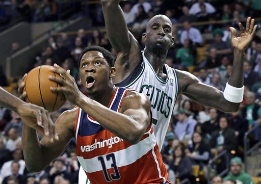 Washington Wizards forward Kevin Seraphin (13) drives to the basket past Boston Celtics forward Kevin Garnett during the first half of an NBA basketball game in Boston on Wednesday, Nov. 7, 2012. (AP Photo/Elise Amendola) TD Garden