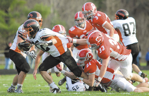 GET BACK HERE: Cony High School’s Brandon St. Michel (31) and Reid Shostak (33) try to bring down Brunswick High School running back Jared Jensen in the first half of a Pine Tree Conference Class A seminfinal game Saturday in Augusta.