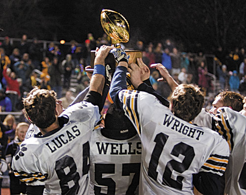 HERE’S TO US: The Mt. Blue football team hoists the gold ball after defeating Marshwood 44-42 in the Class B state championship on Saturday at Fitzpatrick Stadium in Portland.