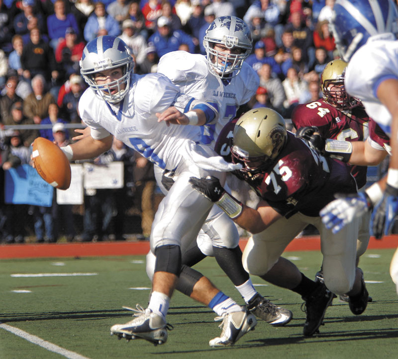 Spencer Carey of Lawrence looks for someone to pass to as he is brought down by Michael Granger of Thornton Academy in the Class A state football championship on Saturday at Fitzpatrick Stadium in Portland. Thornton won, 37-23.