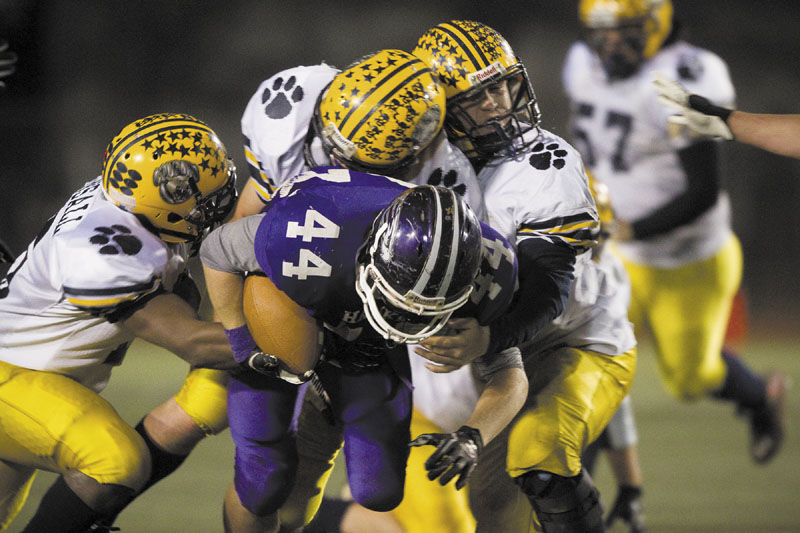 HANG ON: Mt. Blue defenders drag down Marshwood running back Brett Gerry during the second quarter of the Class B state championship game Saturday at Fitzpatrick Stadium in Portland.