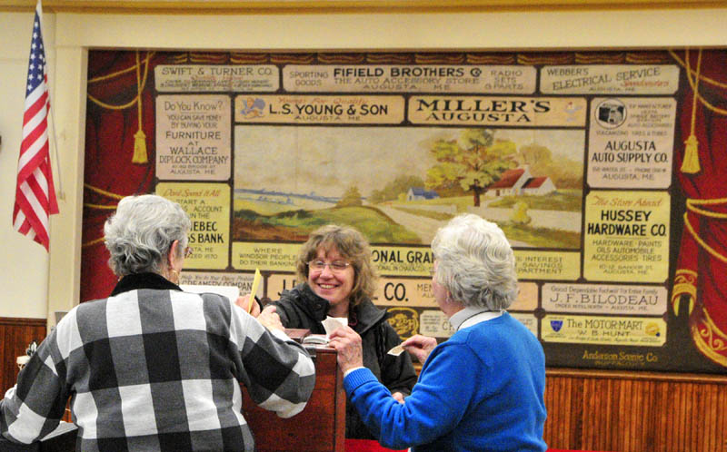 Melissa Morrill, center, chats with election workers Joan Moore, left, and Carolyn Greenwood as she casts her ballot around 5:45 p.m. Tuesday at the Windsor town office.