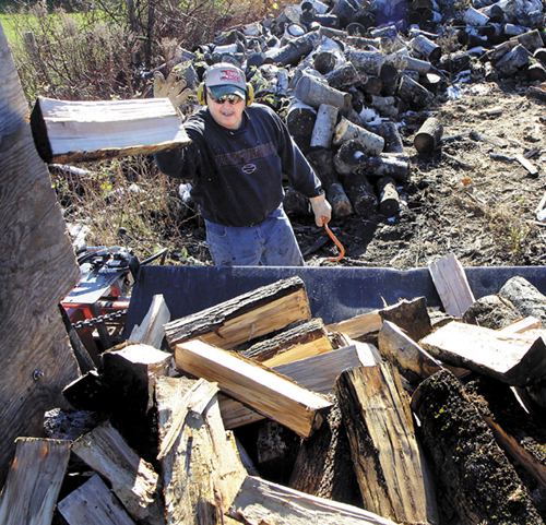 Bruce Lancaster loads a last-minute order of firewood for a customer near his home in North Vassalboro on Friday. Lancaster, who sells firewood as a second job, said he sold around 70 cords of wood so far this year.