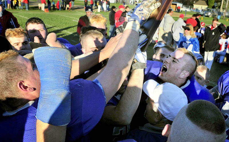 Lawrence High School's Zach Cayer and his teammates celebrate after beating Cony High School 20-10 Saturday to advance to the Class A state football championship.