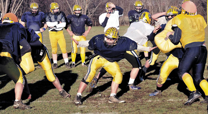 Staff photo by David Leaming Mt Blue football center Drew Blanchet, in center, is seen blocking after snapping ball during practice in Farmington on Wednesday.