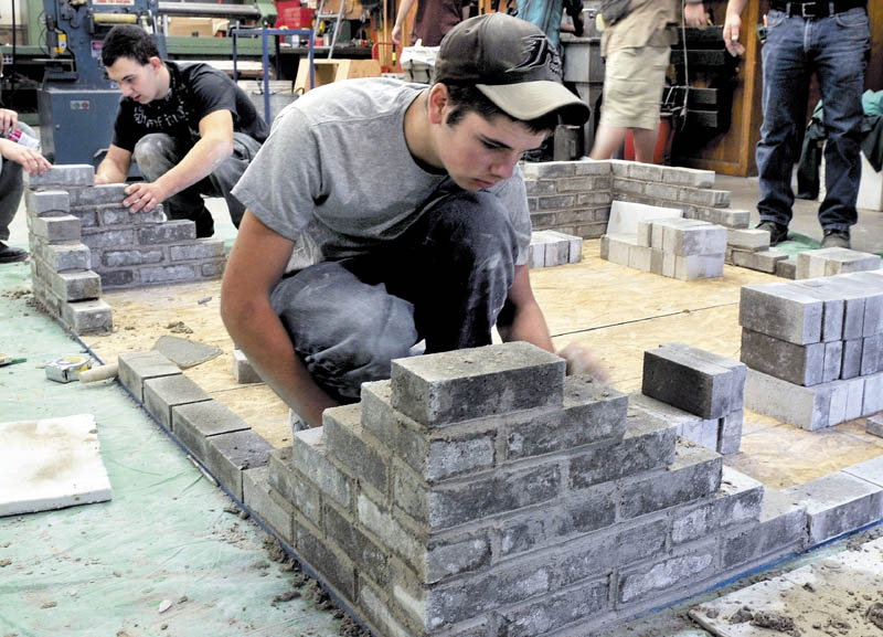 Carrabec High School industrial technology class students Ken White, left, and Francis Musotic build a brick structure on Wednesday. The students are learning skills that will be used when brick benches are made for the new front portico structure.