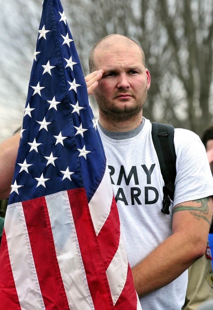 Veteran and flag-bearer Shawn Hayden salutes during the playing of taps, following a ceremony at the Maine Veterans' Memorial Park in Winslow, on Sunday. Veterans and supporters participated in the 13th annual Veterans Day Road March from Augusta to Winslow.