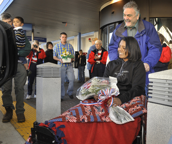 Army Sgt. Helaina Lake, who was severely injured in Afghanistan, returned home to Maine at the Portland Jetport on Tuesday. With assistance from her uncle, Maurice Castonguay, Lake is brought to a limo for the ride home to Livermore Falls.