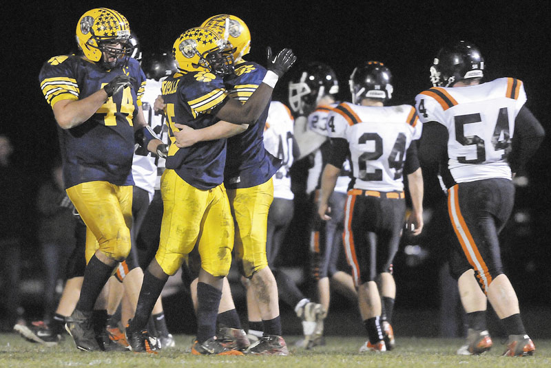 Mt Blue High School's Kindle Bonsall, center, celebrates his 24-yard touchdown catch with quarterback Jordan Whitney, right, in the second quarter against Gardiner Area High School on Friday at Kemp Field in Farmington.