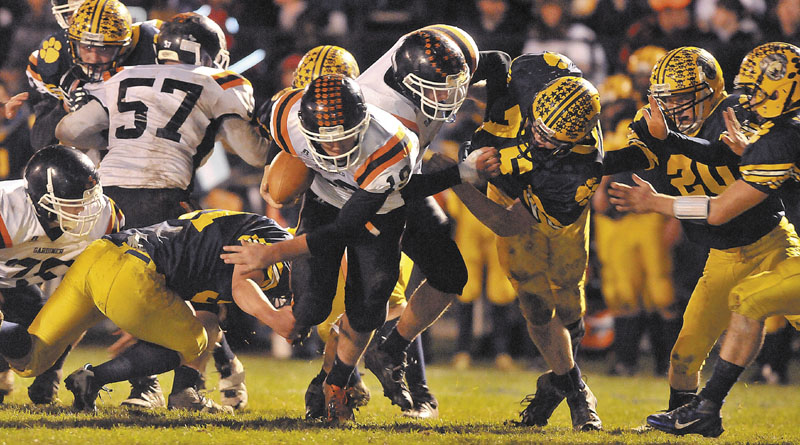 Gardiner High School quarterback Dennis Meehan, 19, breaks through the line on the quarterback keeper against Mt. Blue High School in the second quarter Friday at Kemp Field in Farmington.