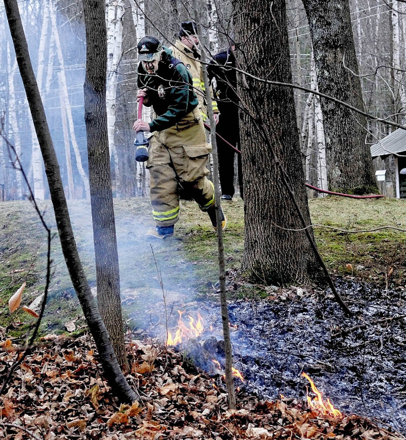 Oakland Deputy Fire Chief Hardy Taylor extinguishes flames sparked after a Libby Hill resident improperly disposed of hot ashes on Tuesday. Fire Chief Dave Coughlin said people need to use caution when getting rid of ashes and coals. "Everything is so dry due to the lack of rain and snow," Coughlin said.