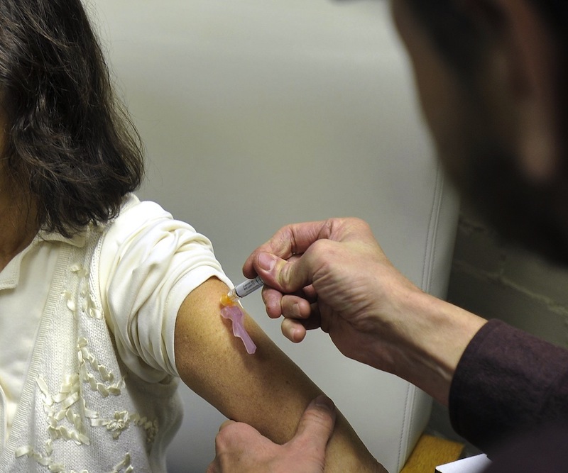 Joanne Yarnold of South Portland receives a flu shot from Bob Barrett at the India Street Clinic, Wednesday, December 5, 2012. This year’s flu strain, which health officials warned would be severe, claimed its first Maine fatality last week, a six-year-old girl from Benton. It's a sobering reminder that everyone over the age of six months should be vaccinated each year, the state CDC director says.