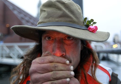 Michael Richard Smith lights a cigarette while speaking with members of the media on a wharf in Boston Harbor on Tuesday. On Monday night, Smith tied up and slept on a floating dock about 100 yards offshore from the New England Aquarium.