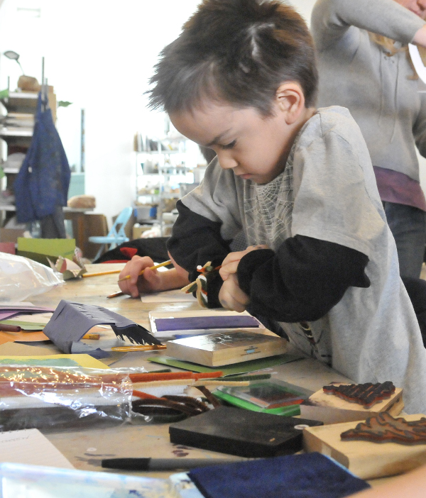 Bryce Keith, 6, selects a Christmas tree stamp during a holiday card-making workshop at Common Street Arts in Waterville on Saturday.