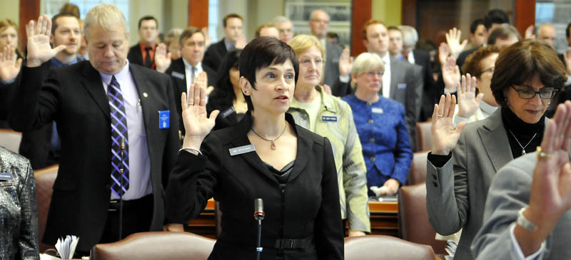 Gay Grant, D-South Gardiner, center, takes the oath of office Wednesday as a state representative at the House in Augusta. All Senate and House members were sworn in for the 126th Legislature by Gov. Paul LePage.