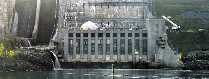 An angler casts for a fish beneath Wyman Dam in Moscow this summer. The 84-megawatt dam, owned by NextEra Energy Partners, is being sold, along with a portfolio of Maine dams, to Brookfield Renewable Energy Partners, a Canadian firm.