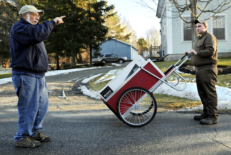 George Sparacio, left, gives UPS driver helper Joseph Ouellette some directions Thursday in Gardiner. Ouellette said he covers several miles a day delivering packages with the push cart. "It's good exercise," he said of his part-time job. Sparacio was walking near his home.