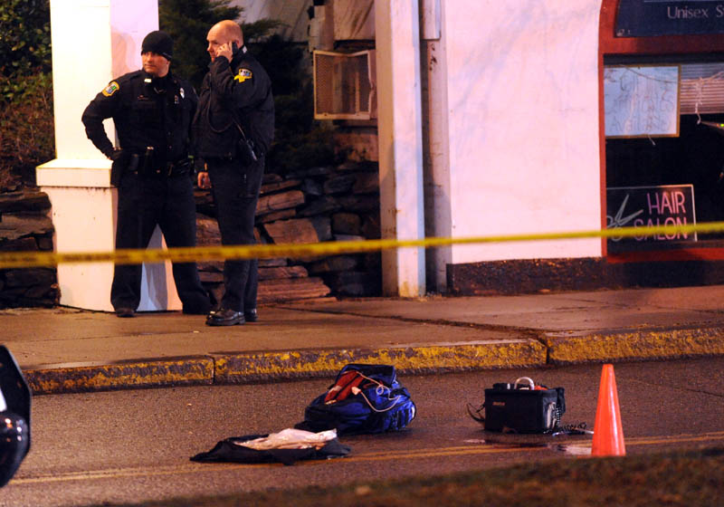 Staff photo by Michael G. Seamans Police investigate the scene where a man was shot on The Concourse late Tuesday night in Waterville.