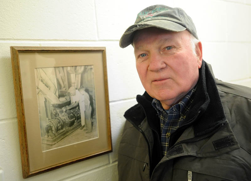 Dale Watson stands next to picture of himself and his father, Charles, at the Somerset Grist Mill, taken in 1941, on Wednesday.