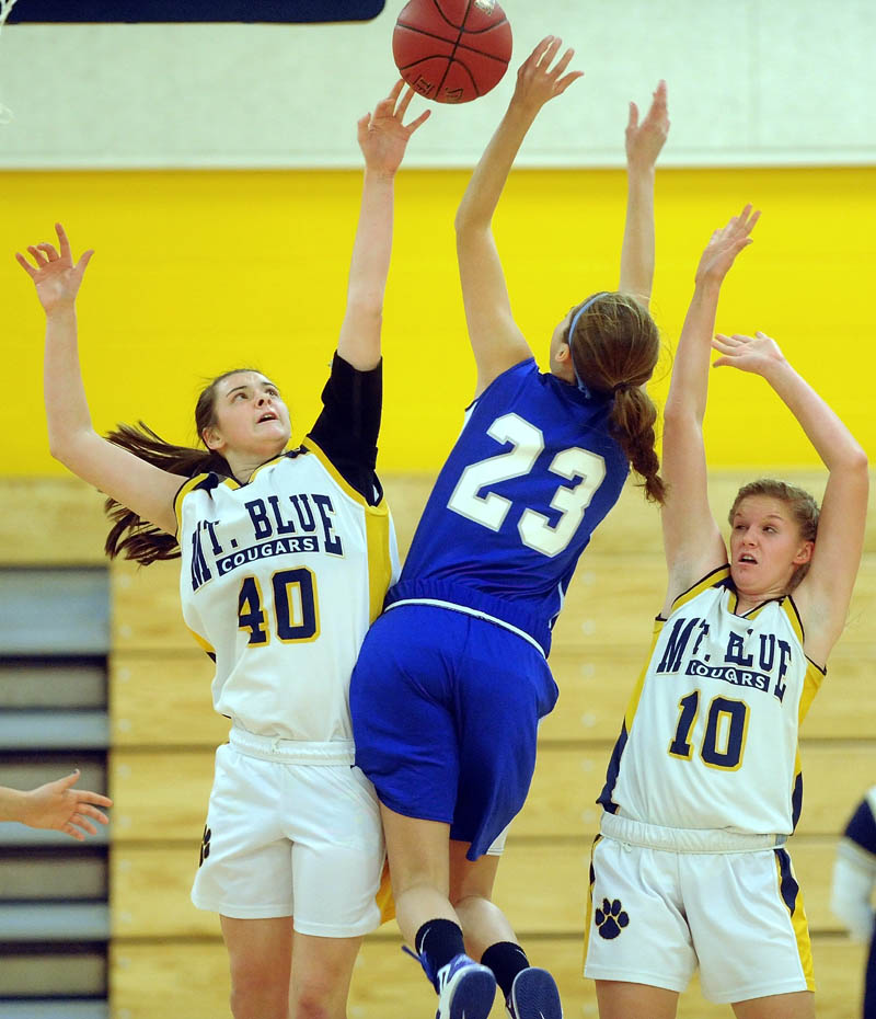 Mt. Blue High School defenders Addie Brinkman, eft, and teammate Jaycee Jenckes, right, try to block a shot by Lawrence High School's Paige Belanger, in the second quarter Friday at Mt. Blue High School in Farmington.