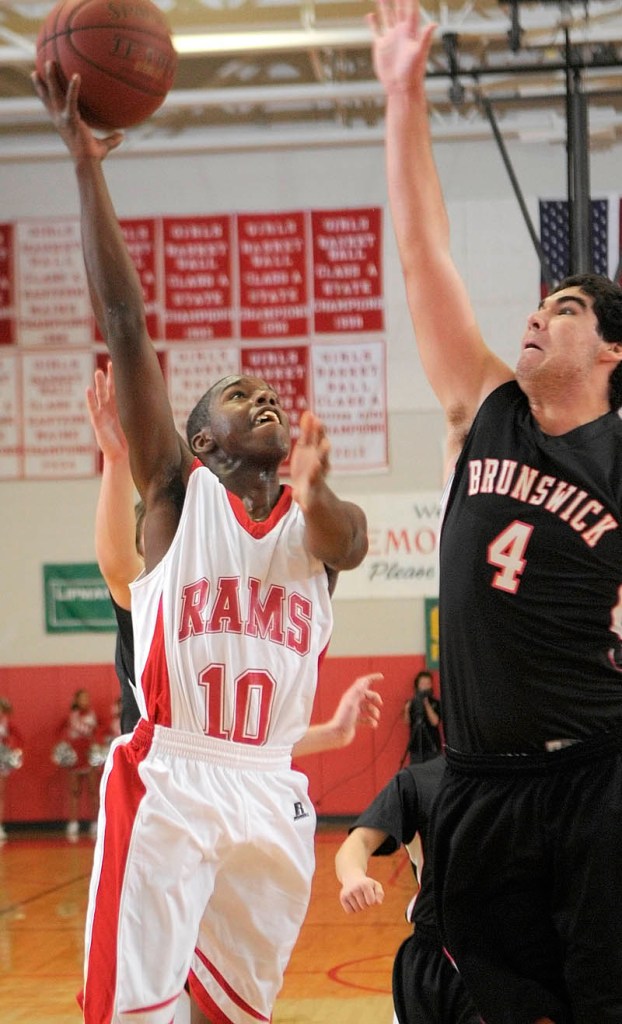 UP AND OVER: Cony’s Dayshawn Roberts, left, shoots over Brunswick’s Bradford Smith on Friday at the Allen and Diane Ryan Family Gymnasium in Augusta.