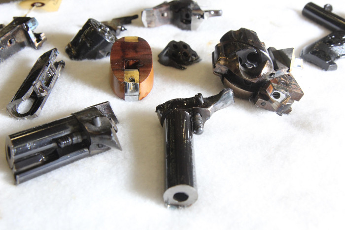 Pieces of destroyed firearms lie on a table at Hammond Tractor Co. in Fairfield on Friday. In the wake of the Newtown, Conn. shooting, Hammond Tractor is offering to accept and destroy firearms.