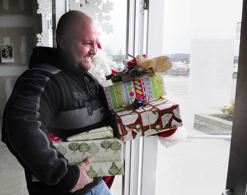 After getting presents wrapped for him by volunteers, Bobby Miller walks out of the United Volunteers of Maine's Santa's Other Workshop, at the Marketplace in Augusta, on Sunday. The workshop is located between the Dress Barn and Home Depot and isopen from Monday to Friday from 4:30 to 8 p.m. this week. In addition to wrapping gifts in exchange for a donation, Santa's Other Workshop offer pictures with Santa and is a dropoff point for several charity toy drives.