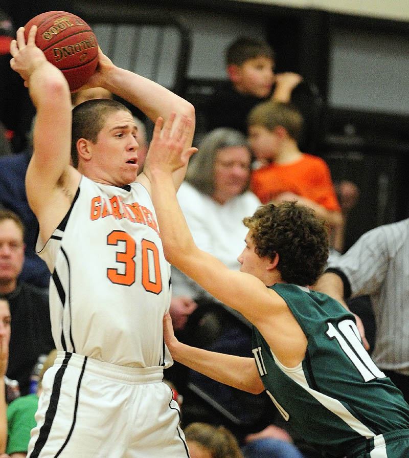 Gardiner's Dennis Meehan, left, looks for a teammate to pass to as Leavitt's Sam Green tries to block his view during a game on Friday at the James A. Bragoli Memorial Gym in Gardiner.