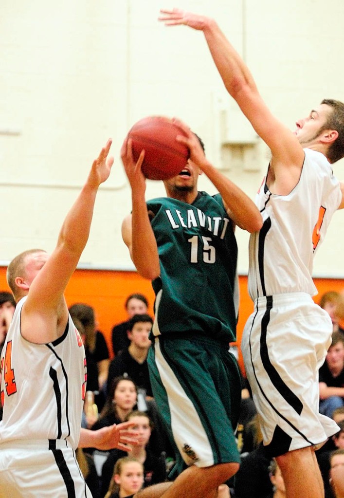Leavitt's Andrew Middleton, center, is double teamed by Gardiner's Brad Weston, left, and Tyler Jamison during a game on Friday at the James A. Bragoli Memorial Gym in Gardiner.