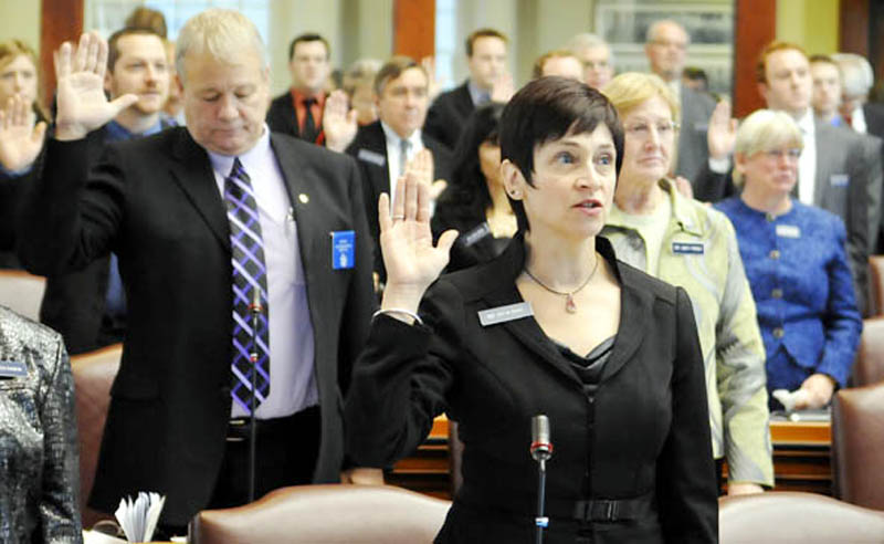 Gay Grant, D-South Gardiner, center, takes the oath of office as a state representative Wednesday at the State House. All Senate and House members were sworn in for the 126th Legislature by Gov. Paul LePage.