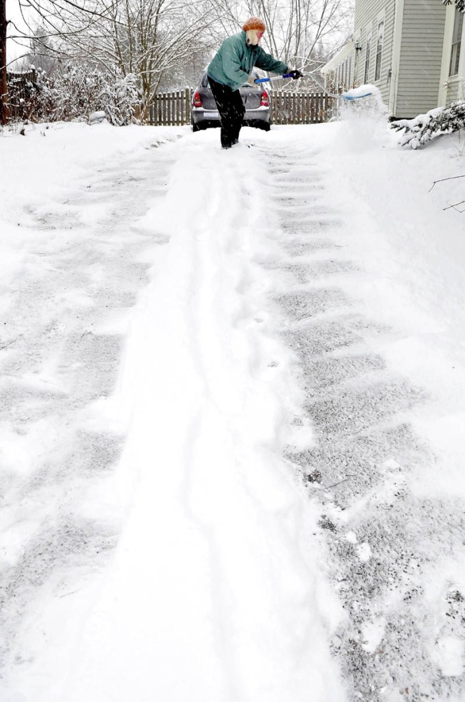 Judy Stoodley shovels snow off her driveway in Unity on Monday. "I think I am one of the few that do it this way anymore," Stoodley said.
