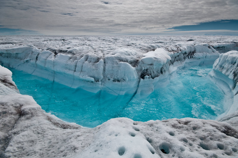 Water from melted ice rushes along the surface of the Greenland ice sheet through a supra-glacial stream channel in this July 4 photo. A new report says heat-trapping pollution from all nations increased by about 1 billion tons last year.