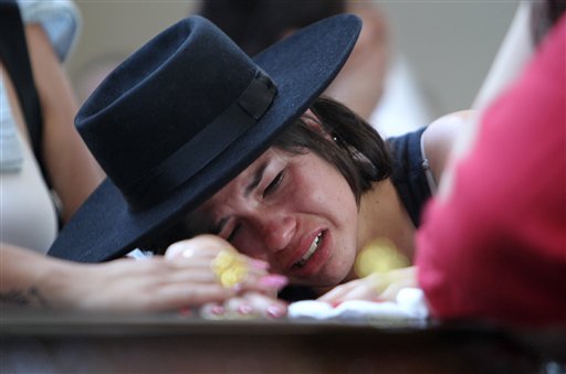 A woman cries over the coffin of her boyfriend at a gymnasium where bodies were brought for identification in Santa Maria, Brazil, on Sunday. They were both at the Kiss nightclub when flames raced through the crowded club.