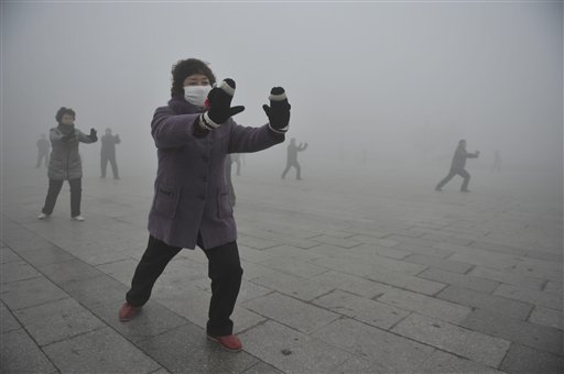 Retirees do Taichi during their morning exercise on a hazy day in Fuyang city, in central China's Anhui province on Monday.