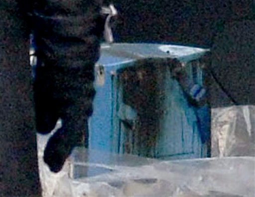 Officials stand beside a main battery that was removed from an electrical room beneath the cockpit of an All Nippon Airways 787 at Takamatsu airport in western Japan.