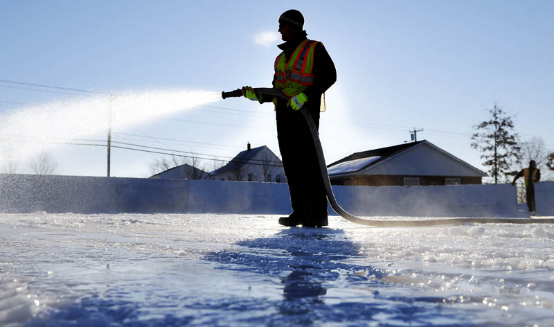 PERFECT ICE CONDITIONS: Augusta Parks, Cemeteries & Trees employee Rich Wurpel coats the Calumet Playground rink with a coat of ice as temperatures hover near 0 F. Thursday January 3, 2013 in Augusta. Crews were skimming the rink in sub-zero temperatures to build a base of ice for skaters this winter.