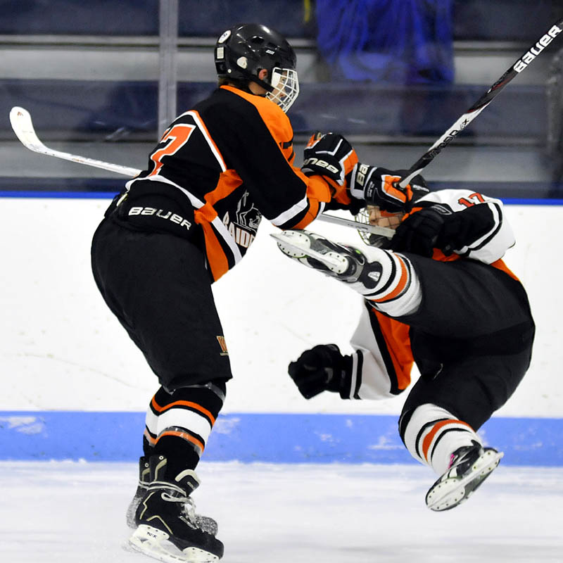 Winslow High School’s Alex Berard, left, knocks down Gardiner Area High School’s Dalton Sargent during their game Thursday at the Bank of Maine Ice Vault in Hallowell.