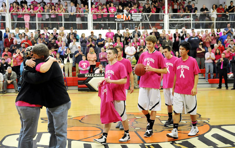 SUPPORT: Hall-Dale High School basketball players approach their former coach, Jim Patrick, as he hugs his wife, Cheryl, before a game Thursday in Farmingdale. The school held a fundraiser for cancer research. Cheryl Patrick is fighting cancer.