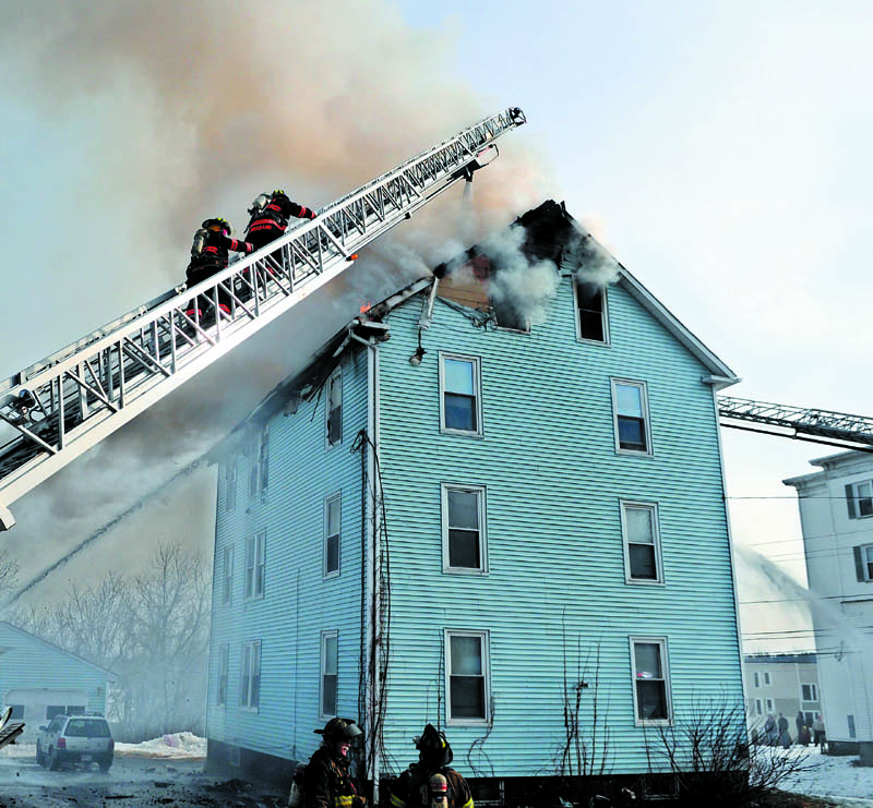 Firefighters attack a blaze Tuesday at 1 Penobscot St. in Augusta, which that damaged the apartment building. Firefighters from several communities fought the fire, but no injuries were reported, according to firefighters.