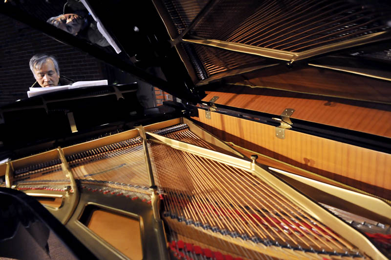 Pianist Masanobu Ikemiya rehearses Sunday on a grand piano donated to the University of Maine at Augusta by the school's Senior College. Ikemiya performed during a concert at Jewett Auditorium at UMA.