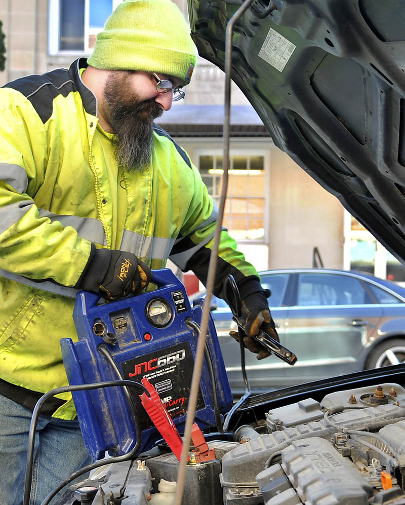 Greg Tisdale, of AC Towing in West Gardiner, jump starts a car Wednesday on Water Street in Gardiner amid single digit temperatures. "It's real busy," Tisdale said. "Over a dozen jump starts and tire changes today."