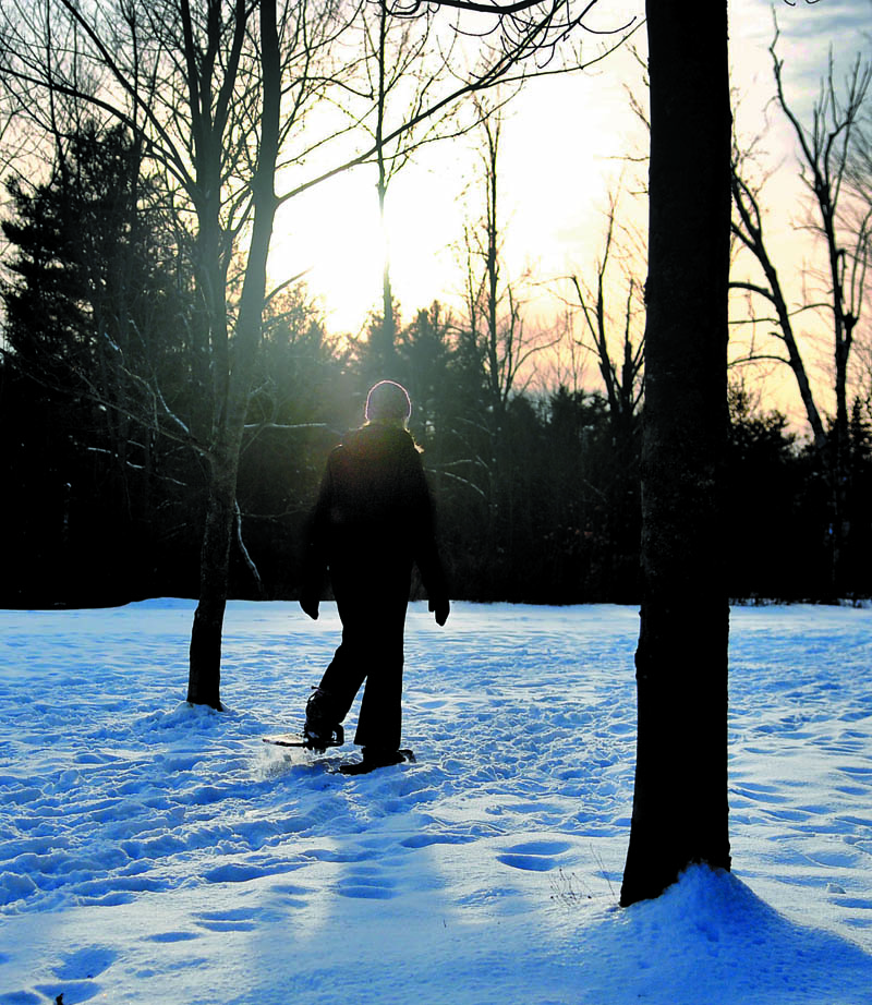 Jessica St. Amand, of West Gardiner, walks into the woods on a pair of snowshoes Thursday in Hallowell. St. Amand was taking a break from appointments as a massage therapist "to get a little exercise."