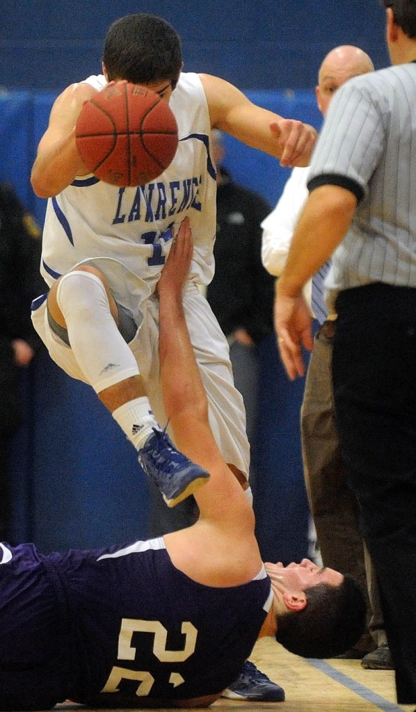 LOOK OUT BELOW: Lawrence High School’s Spencer Carey, top, saves the ball as Hampden Academy’s Matthew Martin tries to make the steal Tuesday in Fairfield.