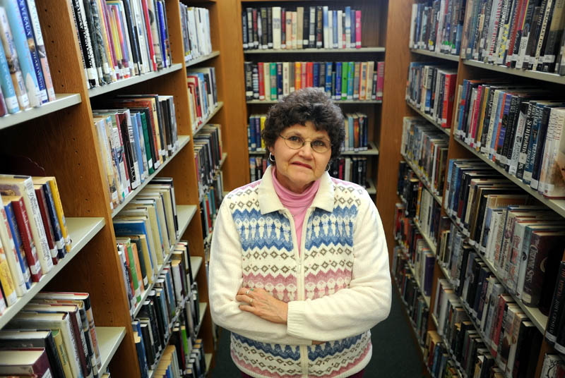 Carol Cooley, a librarian at the Oakland Public Librar,y stands among some books available for checkout on Thursday. Cooley called the police on a delinquent book borrower who failed to return $200 in books.